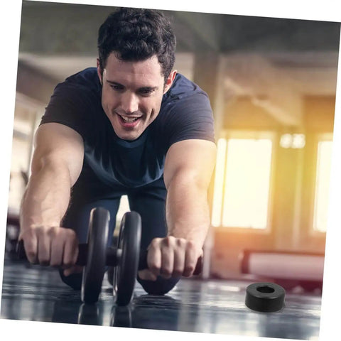 Person exercising with ab roller, rubber bumper visible on gym floor.