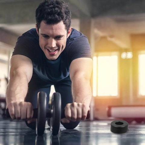 Man exercising with ab roller in gym, Anti Vibration Feet Pads For Gym Equipment 4 Pack Rubber Bumpers visible on floor