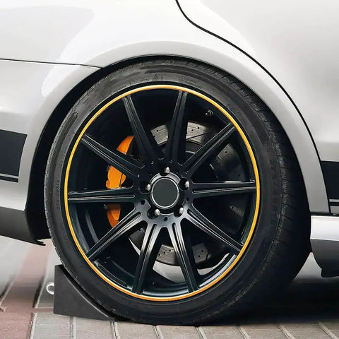 Rugged 2 Pack Solid Rubber Wheel Chocks for RVs, Campers, Trailers and Trucks, Heavy Duty Tire Blocks in use with car tire.
