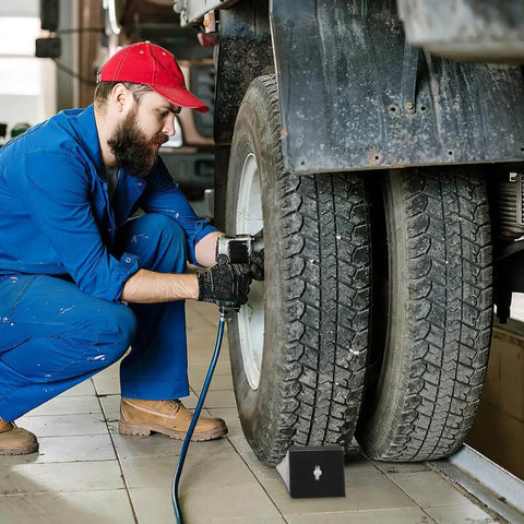 Mechanic working on truck with Rugged 2 Pack Solid Rubber Wheel Chocks for RVs, Campers, Trailers and Trucks under wheel