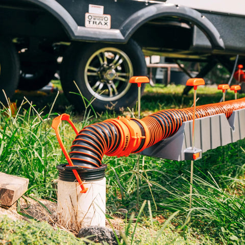 Installed 3 In 1 RV Sewer Hose Adapter And Drain Seal With RhinoExtreme Hose And Handle, connected to 4 inch inlet, in-use view
