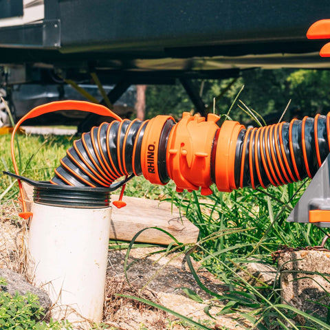 3 In 1 RV Sewer Hose Adapter And Drain Seal With RhinoExtreme Hose And Handle connected to a 4-inch inlet at campground.
