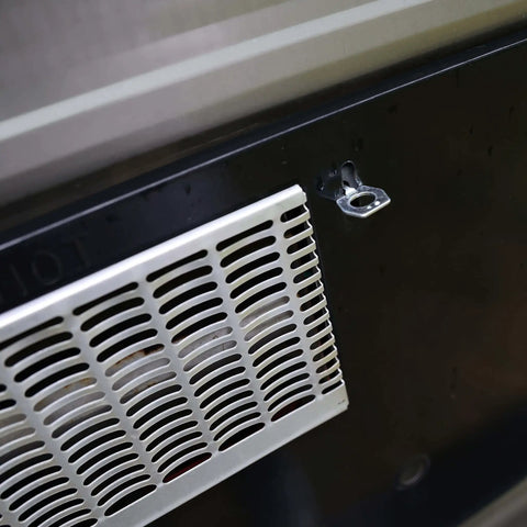 Close-up of RV water heater cover with visible stainless steel cam lock fastener, designed to replace a broken water heater door latch quickly.