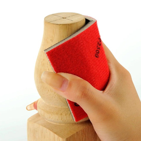 Hand using 24 Piece Sanding Sponge Set 180 To 3000 Grit Foam Hand Sander 3x4in Wet Dry on wooden surface