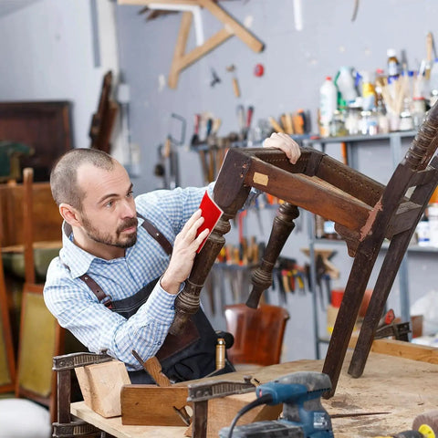 Carpenter using 24 Pcs Sanding Sponges 800 1000 Grit Reusable Blocks For Wood Metal Drywall on wooden chair in workshop.