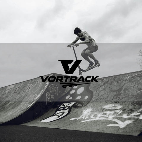 Skater performing a jump on half-pipe with Vortrack logo in foreground, monochrome image