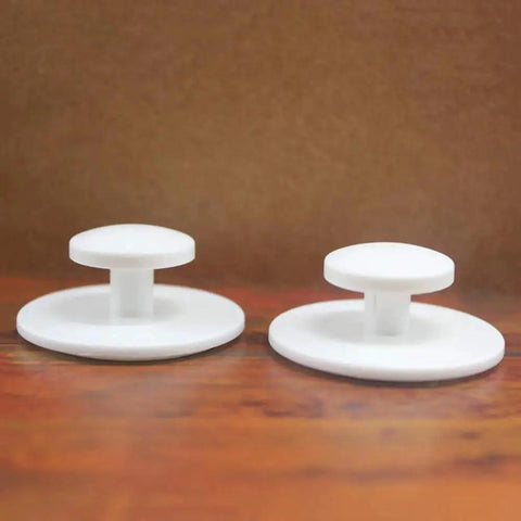Two white knobs from the Ten Piece Pack Self Stick Drawer Knobs For Cabinets And Doors No Glue Needed Peel And Stick Installation Easy To Install Mini Handles.
