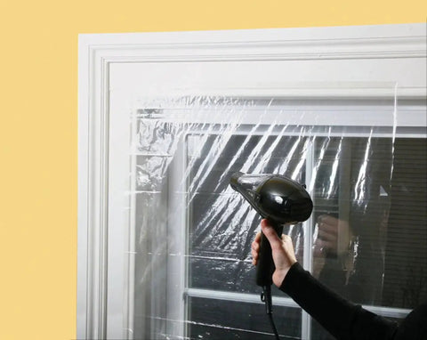 Person using hairdryer to install Indoor Shrink Window Kit For Large Windows And Patio Doors 84 Inch By 110 Inch Clear Film 1 Sheet