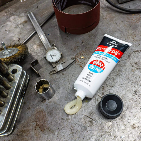 SIL-Glyde Multi-Purpose All-Weather Lubricating Compound for All Surfaces - 8 oz Tube on workshop table with tools