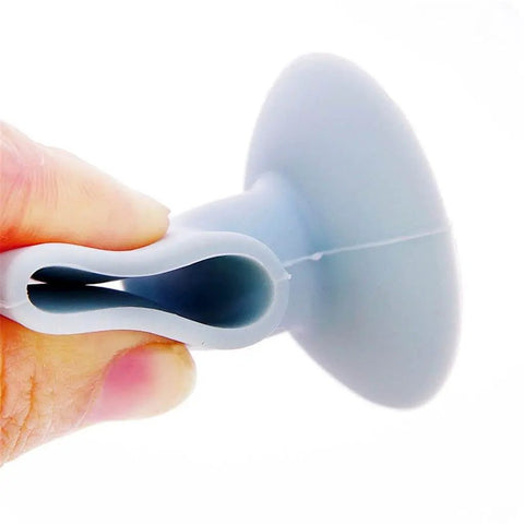 Close-up of a soft silicone anti collision door pad with suction cup attachment, held in hand. Designed to protect walls and reduce noise.