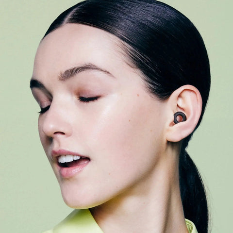 Woman wearing Ultra Comfortable Reusable Ear Plugs With 24 Decibel SNR Noise Reduction For Sleep Deep Focus Travel And Noise Sensitivity