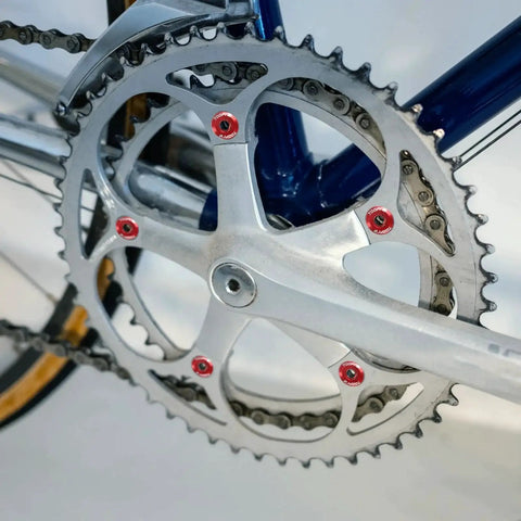 Close-up view of a bike chainring with blue M8 aluminum chainring bolts set delivering CNC precision, anodized finish, and lightweight security for securing chainrings and brake discs on road, mountain, BMX, and track bikes with a clean color matched look.