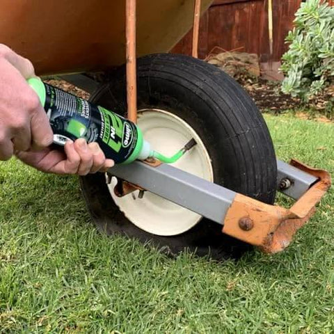Applying Slime 10193 Tire and Tube Sealant to a wheelbarrow tire on grass, non-toxic eco-friendly 2-in-1 16oz bottle
