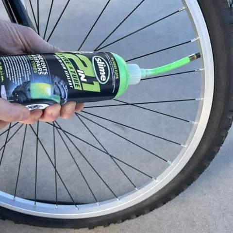 Slime 10193 Tire and Tube Sealant Puncture Repair Sealant, 2-in-1, Premium, in use on a bicycle tire, non-toxic, 16oz bottle