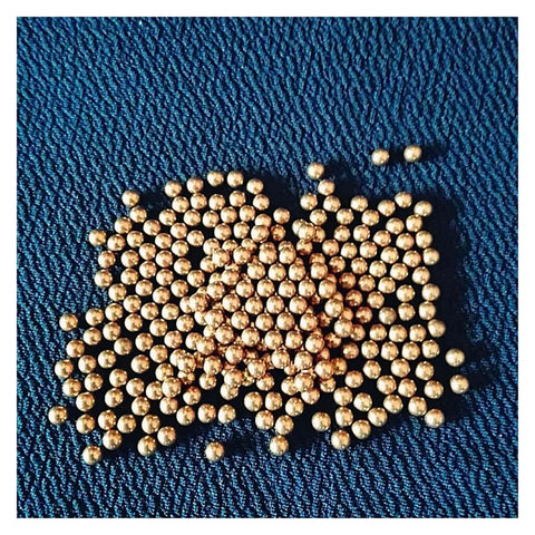 100-Pack 3.175mm Ceramic Balls Solid H62 Brass Ball - Precision Smooth Beads Round Balls displayed on blue fabric