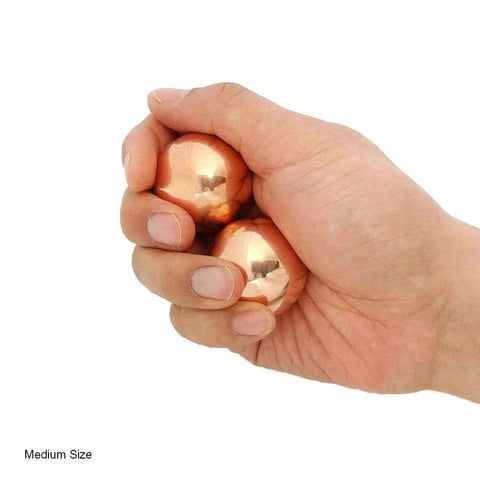 Hand holding 1.5 Inch Solid Copper Baoding Balls with Carry Pouch for Hand Therapy, Exercise, and Stress Relief