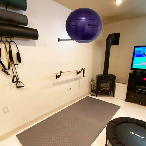Wall Mounted Stainless Steel Exercise Ball Holder for 13 to 34 Inch Balls in home gym with yoga and stability accessories