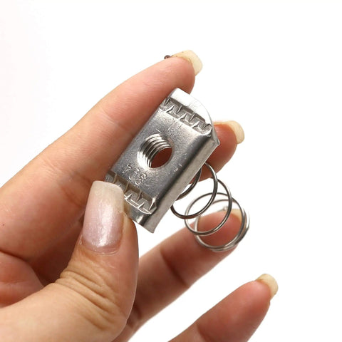 Hand holding stainless steel 3/8-16 standard strut channel nut with thickened spring for mounting and connecting slotted strut systems.