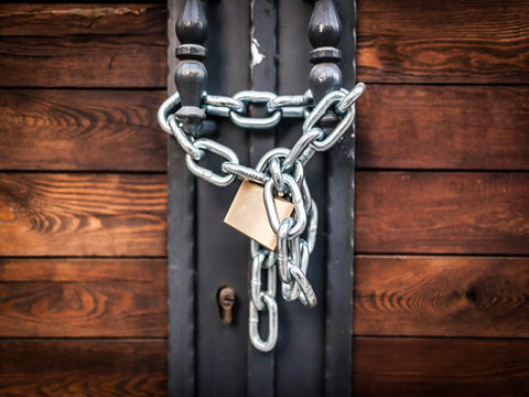 Chain and padlock securing a wooden gate, representing the utility of 2 Pcs 1/4 x 23 inch Link Chain 304 Stainless Steel.