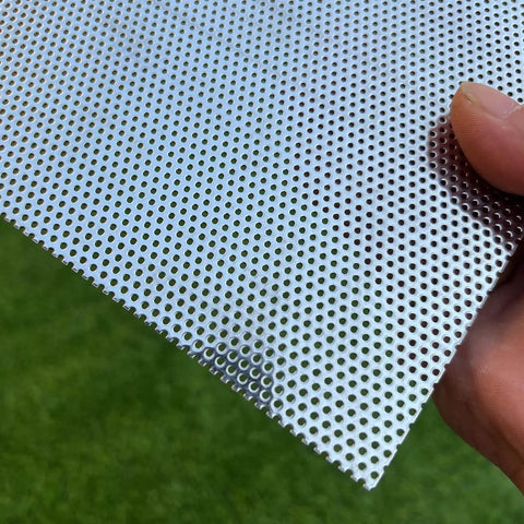 Close-up of stainless steel perforated sheet 16x10 in, 304 grade, 19 gauge with 1/16 inch openings, held by a hand
