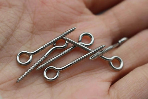 100 Pack Stainless Steel Screws 1 Inch 25mm For Jerk Baits Lure Making And DIY Fishing Lures Hardware Silver Finish For Crankbait And Lure Assembly Durable And Corrosion Resistant For Saltwater Use shown in hand.