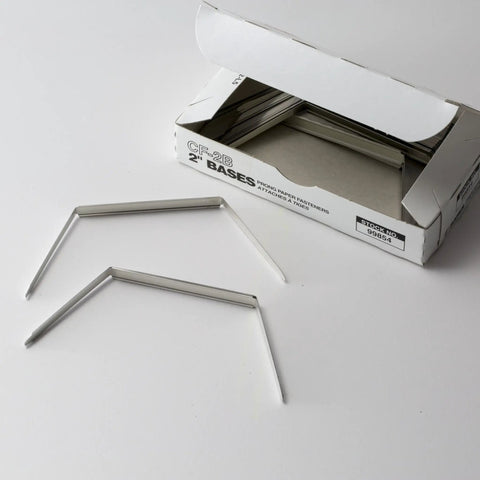 Prong Fastener Bases For Officemate OIC99854 Heavy Duty Steel Two And Three Quarters Inch Center To Center Two Inch Sheet Capacity 100 Per Box Silver Finish Corrosion Resistant shown with box and two fasteners.