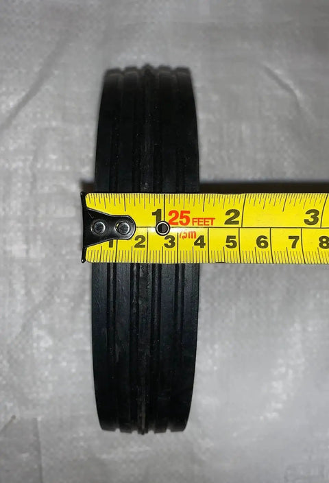 Close-up of 7 Inch By 1.5 Inch Steel Ball Bearing Wheel For Power Trim Edger Replacement OEM Part 332 with tape measure
