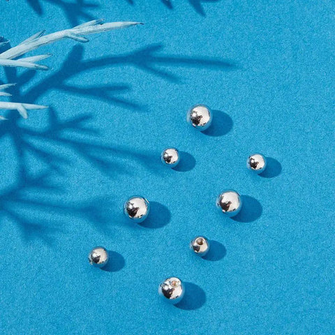 925 Sterling Silver Screw Ball Backings for Earrings, round 3-4mm, loose on blue background, hypoallergenic jewelry making supply.