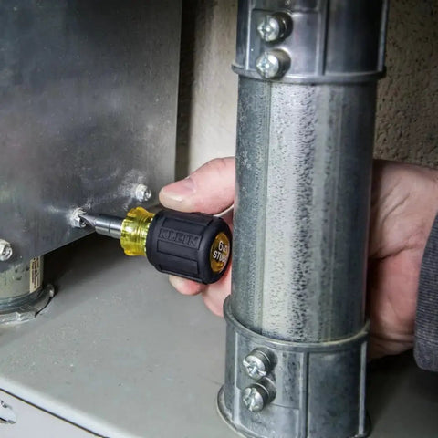 Person using 6-In-1 Stubby Screwdriver And Nut Driver with Interchangeable Shaft on metal panel