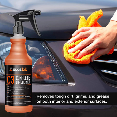 Suds Lab C3 Complete Car Cleaner, Multipurpose Car Wash Solution for Interior and Exterior Cleaning, Spray for Automotive Detailing, 32 oz bottle next to a person cleaning a car's exterior with an orange cloth.