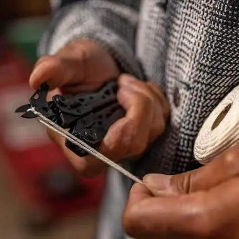 Person cutting rope with Suspension-NXT 15-In-1 EDC Multi Tool with Pocket Knife and Needle Nose Pliers