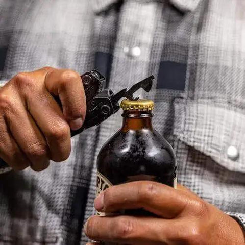 Person using Suspension-NXT 15-In-1 EDC Multi Tool With Pocket Knife to open a bottle, showcasing the bottle opener tool.