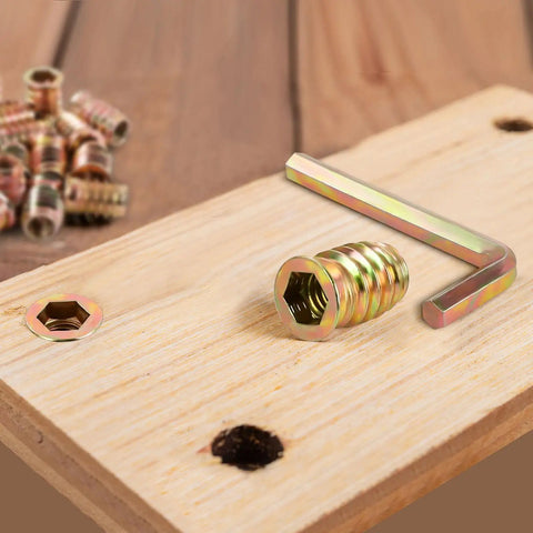 Three Eighths Inch Threaded Wood Inserts For Furniture Nutserts With Hex Drive Sixteen Threads Per Inch on wood surface.