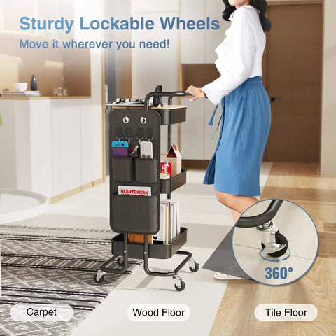 Person pushing a Three Tier Metal Utility Rolling Cart With Table Top And Side Bags Mesh Tray Storage Organizer On Wheels With Four Hooks in a living room.