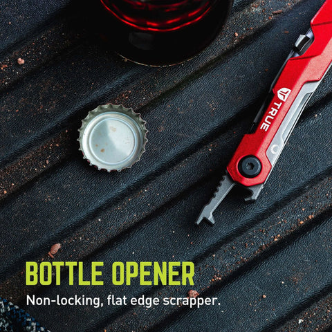 Close-up of ✝️ TRUE Titanium Block Multitool with bottle opener and red handle on textured surface next to open bottle cap.