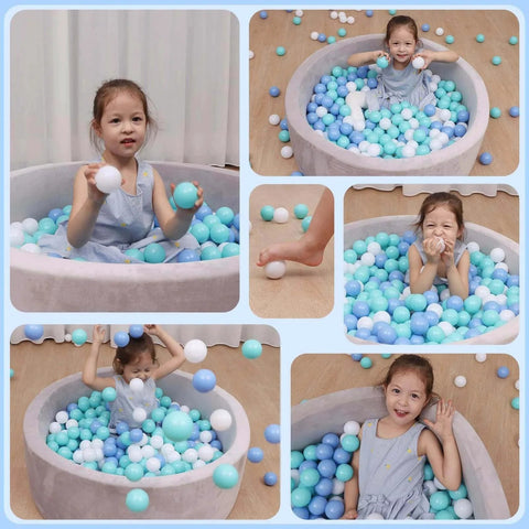 Child playing in ball pit with Ball Pit Balls for Toddlers, BPA Free Crush Proof Plastic Toy Balls in white, green, and blue.