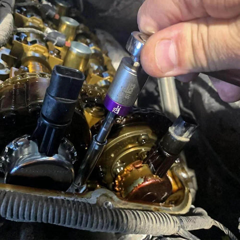 Large Torque Limiter in use with 1/4" driver on automotive engine assembly, precision tool for accurate torque control, 70 in-lb setting.