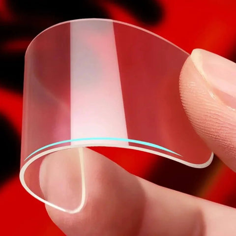 Close-up of a hand holding a transparent, flexible square tape from Double Sided Adhesive Pads Square Transparent Tape Cuttable For Walls Hangin