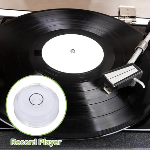 Black vinyl record on turntable with white center and stylus arm, inset image of round bubble level with "Record Player" text