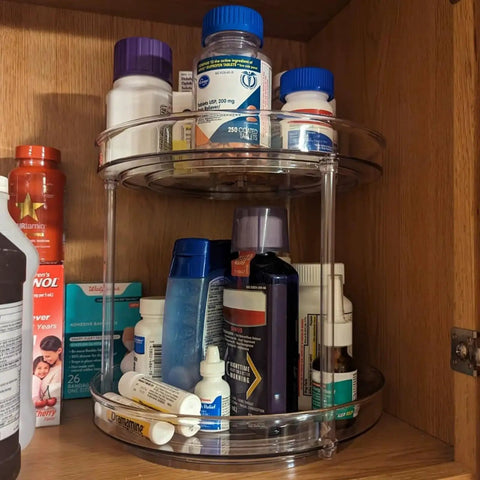 Two Tier Clear Lazy Susan Turntable Organizer With 360 Degree Rotation For Vanity And Bathroom Storage Spinning Makeup Skincare Perfume Holder Spice Rack And Cabinet Organizer For Kitchen Pantry holding medicine bottles and toiletries in a cabinet.