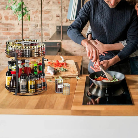 Two Tier Rotating Spice Organizer Turntable on kitchen counter with spices and sauces, showing height adjustable shelves