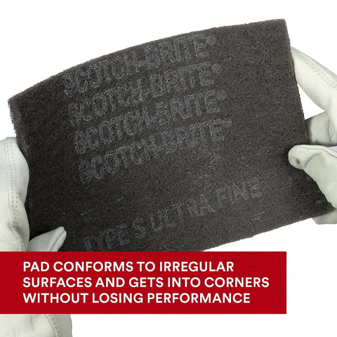 Person holding a 6x9 Ultra Fine Hand Pads Nonwoven Silicon Carbide for surface prep, showing durability and flexibility