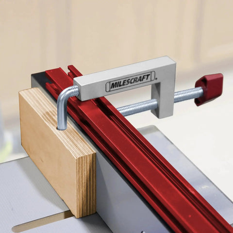 Universal Fence Clamp Set For Miter Saws And Router Tables Milescraft 7209 showing clamp securing wood to red guide rail