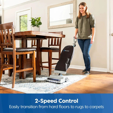 Woman using Ultra Lightweight 14L Bagged Upright Vacuum Cleaner With LED Headlight And 2 Speed Settings on hardwood floor next to carpet