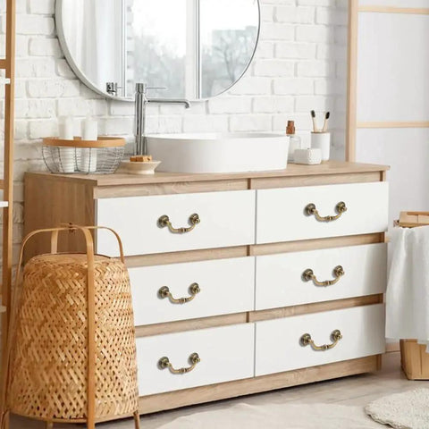 Set Of Six Vintage Bail Pull Handles In Antique Bronze Alloy For Cabinets And Drawers installed on white drawer in a bathroom.