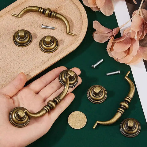 Set Of Six Vintage Bail Pull Handles In Antique Bronze Alloy For Cabinets And Drawers, decorative kitchen cupboard pulls displayed on table.