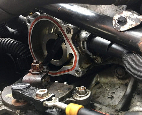 VW vacuum pump housing with red seal gasket on Jetta 2.5L, metal body and rotor visible