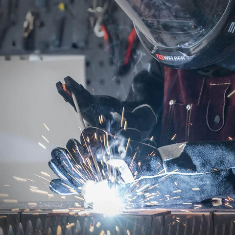 Welder using Stainless Steel Stick Electrodes For All Position Welding E308L16 14 Inch 3 32 Inch 5 Pound Pack with sparks flying