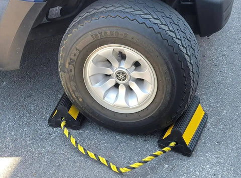 Heavy Duty Wheel Chocks With Ropes For Trucks And Trailers, Oil Resistant Rubber, Reflective Stripes, shown in use with tire