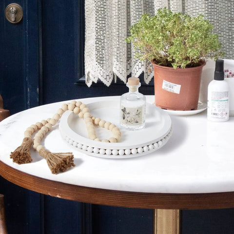 12 Inch White Beaded Lazy Susan Turntable for Tabletop and Countertop as kitchen tabletop centerpiece with beads, plant, and decor items.